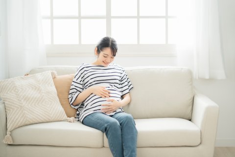 妊婦　お腹　妊娠中　ソファ　マタニティパンツ　マタニティデニム